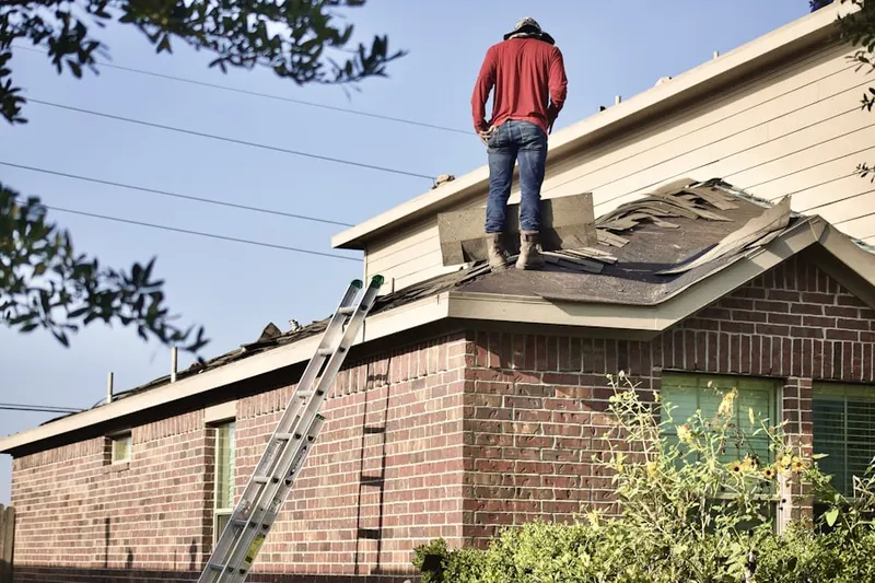 Professional roofer working on a residential roof in Huntington Woods